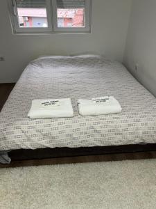 a bed with two towels sitting on top of it at Downtown Great Apartment in Strumica