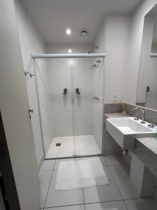 a white bathroom with a shower and a sink at True América apart-hotel in Campos dos Goytacazes