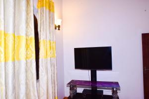 a television sitting on a table next to a curtain at hikka T&O nature villa in Hikkaduwa