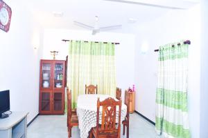a dining room with a table and chairs and a tv at hikka T&O nature villa in Hikkaduwa