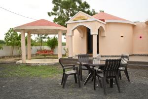 a table and chairs in a yard with a gazebo at Kutch kutir in Bhuj