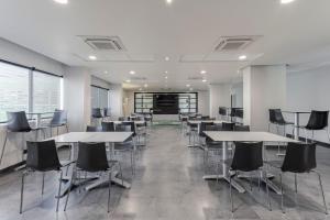 a conference room with tables and chairs in an office at City Express by Marriott Guadalajara Aeropuerto in Guadalajara