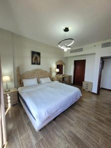 ein Schlafzimmer mit einem großen weißen Bett in einem Zimmer in der Unterkunft Royal Beach Apartment in King Abdullah Economic City
