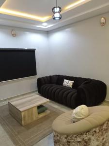 a living room with a black couch and a flat screen tv at OD-V!CK'S CLASSIC, Wuse 2 extension, upscale Jahi district WiFi,24hr power,security, dstv in Abuja