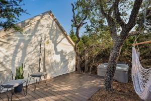 a patio with a hammock and a tree at Oak Retreat Glamping With Private Hot tub in Luckenbach