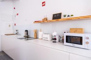 uma cozinha com um balcão branco e um micro-ondas em MAR NEST Lodging - New & cosy house for 2, fully equiped & sea view em Glória