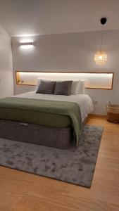 um quarto com uma cama grande e um tapete em MAR NEST Lodging - New & cosy house for 2, fully equiped & sea view em Glória