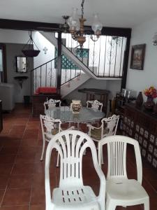 uma sala de jantar com uma mesa e cadeiras brancas em Rústica y armoniosa casa de campo cerca de las estacas em Ticumán