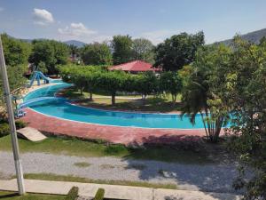 uma imagem de uma piscina num resort em Rústica y armoniosa casa de campo cerca de las estacas em Ticumán