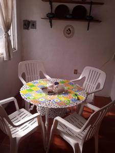 uma mesa com três cadeiras e uma mesa com uma toalha de mesa em Rústica y armoniosa casa de campo cerca de las estacas em Ticumán