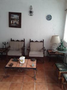 uma sala de estar com duas cadeiras e uma mesa em Rústica y armoniosa casa de campo cerca de las estacas em Ticumán