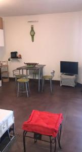 ein Wohnzimmer mit einem Tisch, Stühlen und einer roten Decke in der Unterkunft Appartement meublé in Montpellier