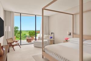 a bedroom with a bed and a desk with a chair at The Riviera Maya EDITION at Kanai in Playa del Carmen