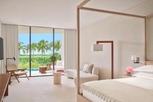 a bedroom with a bed and a living room at The Riviera Maya EDITION at Kanai in Playa del Carmen