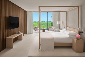 a hotel room with a bed and a living room at The Riviera Maya EDITION at Kanai in Playa del Carmen