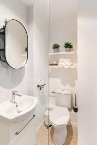 a white bathroom with a toilet and a mirror at Le St Fée - Nid douillet à 100m du vieux port in Marseille