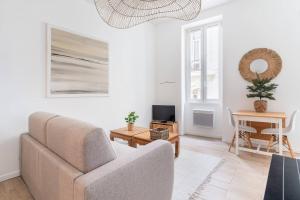 a living room with a couch and a table at Le St Fée - Nid douillet à 100m du vieux port in Marseille +1 photo