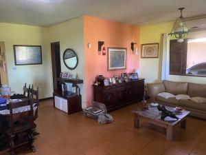 ein Wohnzimmer mit einem Sofa und einem Tisch in der Unterkunft Casa de seis suites na beira do mar in Rio das Ostras