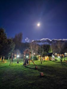 a park at night with the moon in the sky at La Yaya - Villa Turismo in El Bolsón