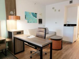 Comfort Suites في فلدوستا: مكتب مع مكتب وكرسي في الغرفة
