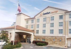 een vooraanzicht van een hotel met een Amerikaanse vlag bij Comfort Suites in Valdosta