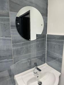 a bathroom with a sink and a mirror at Contractors, Groups 4BR 5xDB Close to City free parking sleeps x 10 in Leeds
