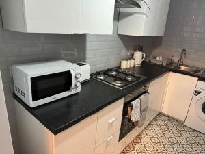 a microwave sitting on a counter in a kitchen at Contractors, Groups 4BR 5xDB Close to City free parking sleeps x 10 in Leeds