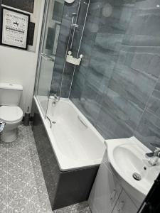 La salle de bains est pourvue d'une douche, de toilettes et d'un lavabo. dans l'établissement Contractors, Groups 4BR 5xDB Close to City free parking sleeps x 10, à Leeds