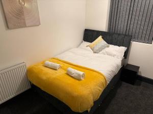 uma cama num quarto com duas toalhas em Contractors, Groups 4BR 5xDB Close to City free parking sleeps x 10 em Leeds