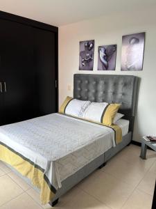 - une chambre avec un grand lit et une tête de lit en métal dans l'établissement Apartamento en valle del Lili, à Cali