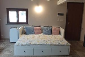 een bed met kussens in een kamer bij appartamento tra Torino e Alba in centro in Sommariva del Bosco