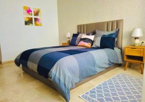 - une chambre avec un grand lit et une couette bleue dans l'établissement Luxe en bord de mer à la Marina d'Agadir, à Agadir