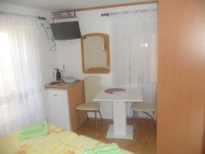 a small kitchen with a table and a mirror at Guest House Leon in Korčula