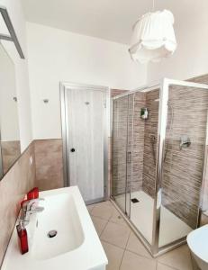 a white bathroom with a shower and a sink at le case di Giulia in Abbadia Lariana
