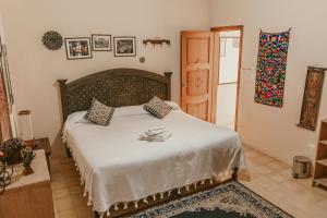 1 dormitorio con 1 cama grande con sábanas blancas en Yagil B&B, en San Cristóbal de Las Casas