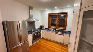 a kitchen with a stainless steel refrigerator and a sink at luxury 5 bedrooms, Pool, Quiet in Melbourne
