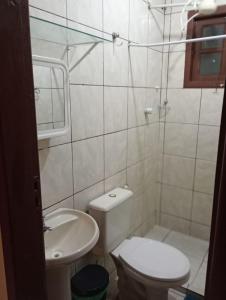 a bathroom with a toilet and a sink at Suite canto do forte in Cabo Frio