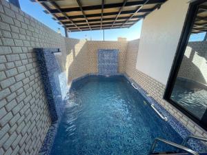 a small pool of water in a brick wall at Tiwi Pearl in Sur