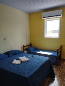 a bedroom with two beds and a window at Pousada São Benedito in Cachoeira Paulista