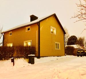 a large yellow house in the snow at Meditation Room with light bfast - private toilet, no shower in Rovaniemi