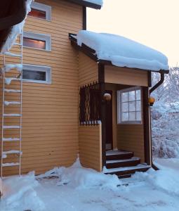 a house covered in snow with stairs and a window at Meditation Room with light bfast - private toilet, no shower in Rovaniemi