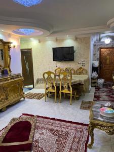 a living room with a table and chairs and a tv at شقة للايجار مفروشة بالكامل in Cairo