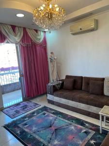 a living room with a couch and a chandelier at شقة للايجار مفروشة بالكامل in Cairo