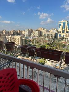 einen Balkon mit mehreren Topfpflanzen auf einer Skyline der Stadt in der Unterkunft شقة للايجار مفروشة بالكامل in Kairo