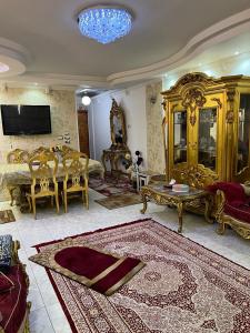 ein Wohnzimmer mit Goldmöbeln und ein Wohnzimmer mit einem Tisch in der Unterkunft شقة للايجار مفروشة بالكامل in Kairo