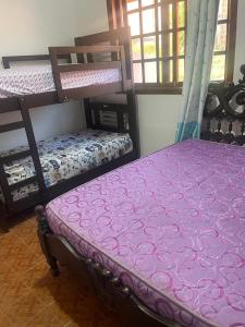 a bedroom with two bunk beds with a purple mattress at Gästehaus Samaipata in Samaipata