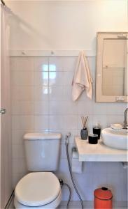 Un baño blanco con inodoro y lavabo. en SUITE DA FRENTE COM COPA, WIFI E ACESSO INDEPENDENTE, en Búzios