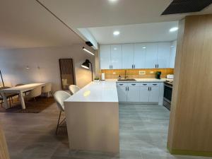 a kitchen with white cabinets and a table and chairs at BA Miami Apartments in Miami Beach