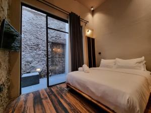a bedroom with a large bed and a large window at Casa Origenes in San Miguel de Allende