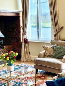 uma sala de estar com um sofá e uma lareira em Stunning Thameside Apartment em Henley on Thames